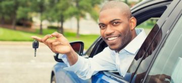 אדם מאושר נוסע ברכב שלו לאר שקיבל הלוואה