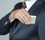 איש עסקים מחזיק כסף שניתן לו כהלוואה מקרן דטרויט